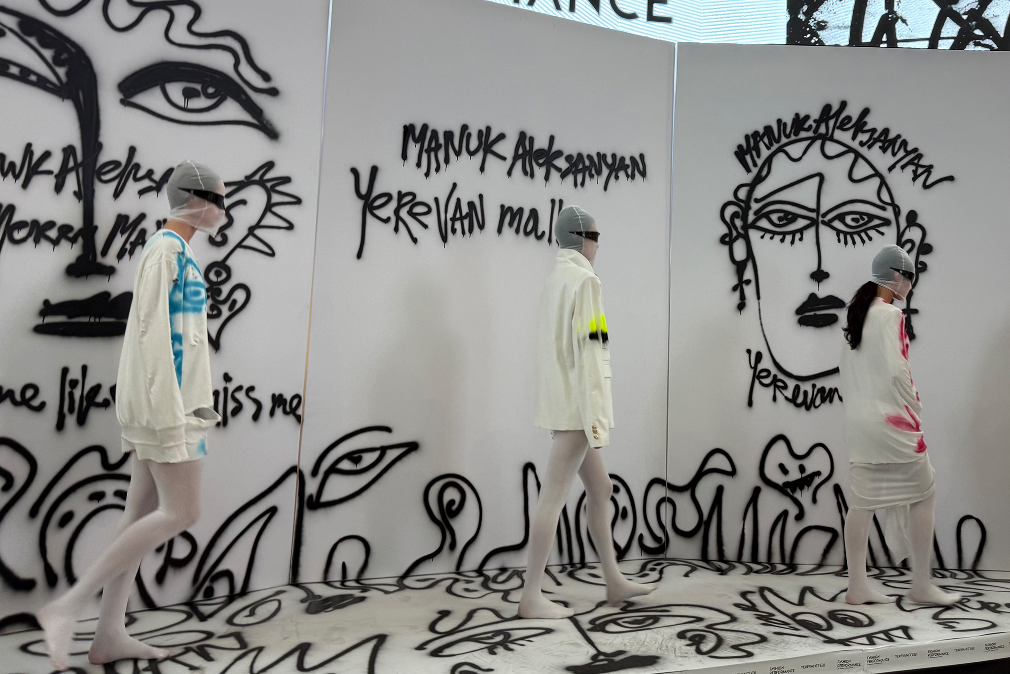 Models walk across the stage showcasing completed looks featuring signature graphic elements during a live fashion performance in Yerevan, Armenia.