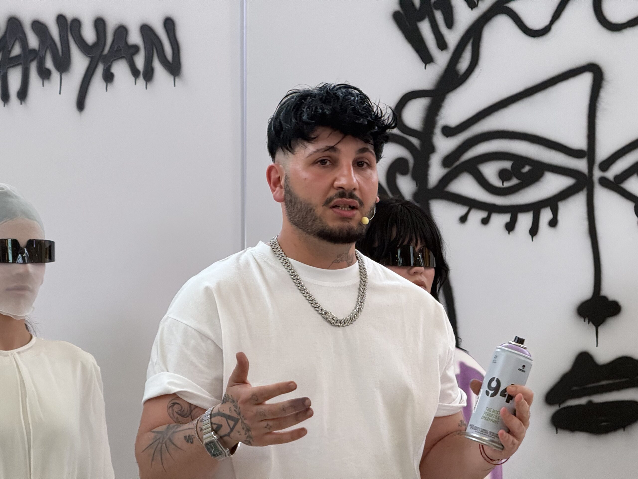 Manuk Aleksanyan speaking to an audience during a live fashion performance in Yerevan.
